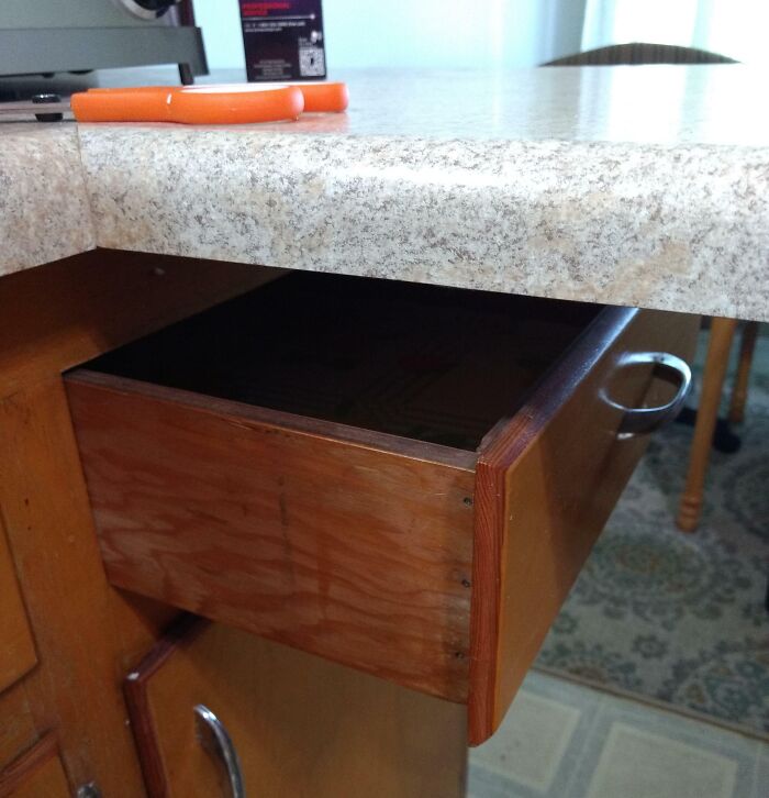Drawer poorly installed under countertop, demonstrating hilariously bad handyman job done just to get it over with.