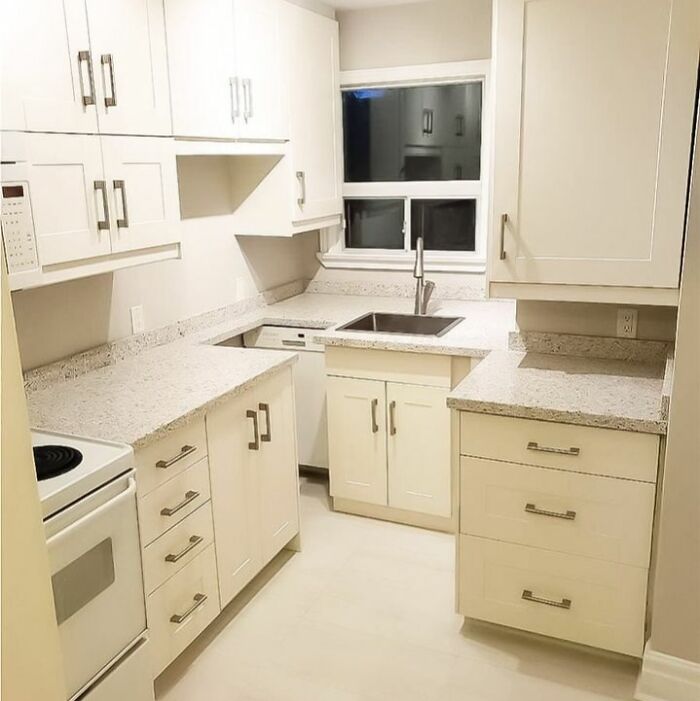 Poorly done kitchen renovation with misaligned cabinets and uneven countertop showing hilariously bad jobs.