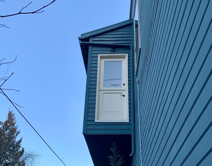 Poorly done home addition with an unusable door hanging above ground, showcasing hilariously bad jobs to get it over with.
