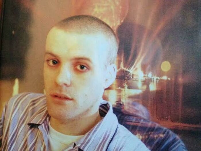 Young male celebrity with short hair posing in front of a blurred nighttime cityscape, linked to vanished celebrity mysteries.