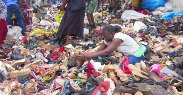Woman searching through a large pile of discarded shoes, highlighting brutal reminders of how bad consumerism has gotten.