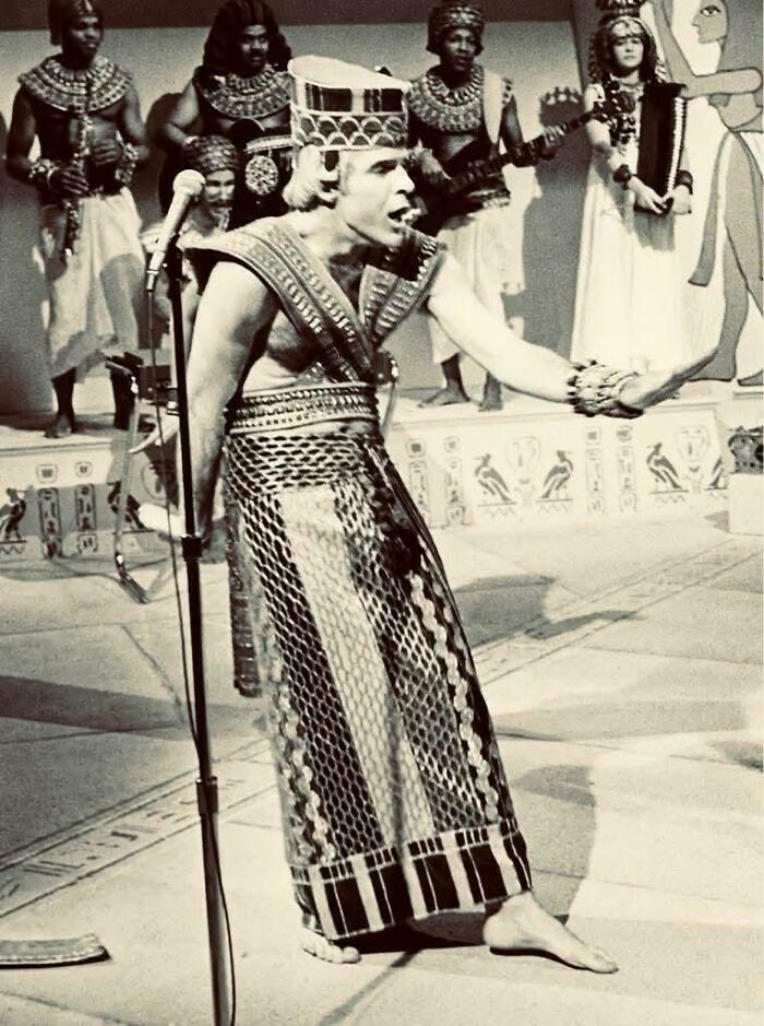 Black and white vintage photo of a man in Egyptian costume performing with a band, evoking nostalgic feel old posts.