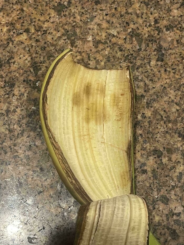 Banana peel showing a faint pattern resembling cute cat paw prints on a granite countertop surface.