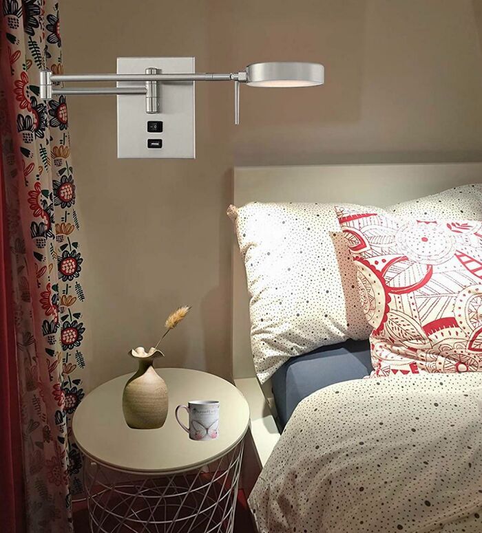 Bedroom scene with a floating wall lamp and a vase levitating above a side table, showing a Photoshop fail.