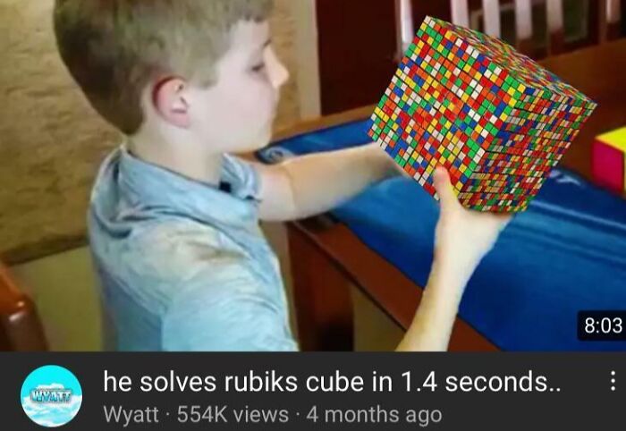 Boy holding an impossibly large Rubik's Cube, an example of Photoshop fails that are so horrible it's hard to believe.