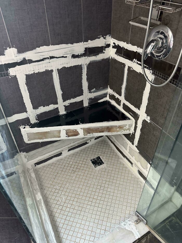 Shower with poorly installed tiles and grout, showing bad workmanship by landlords in a rental property.