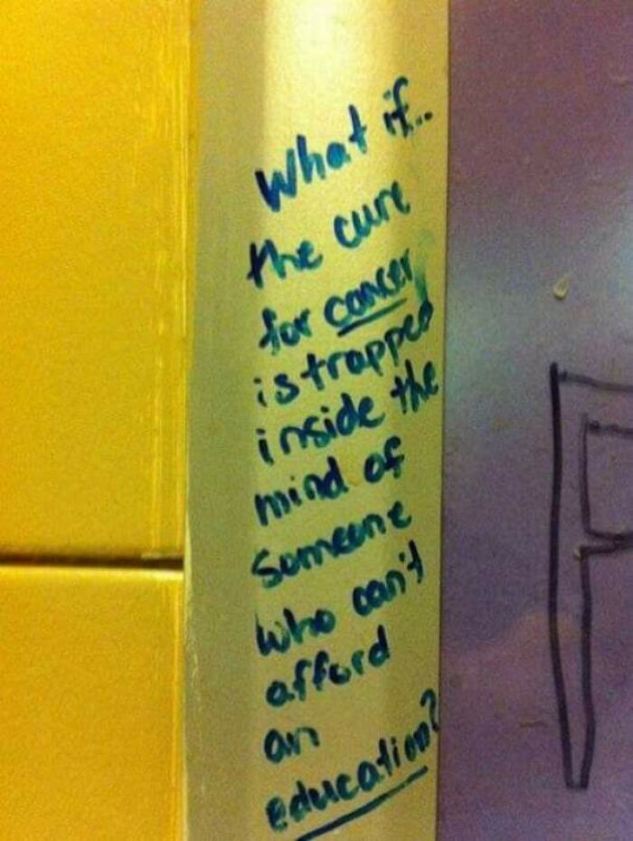 Graffiti on a wall questioning if the cure for cancer is trapped in the mind of someone without education in public property vandalism.