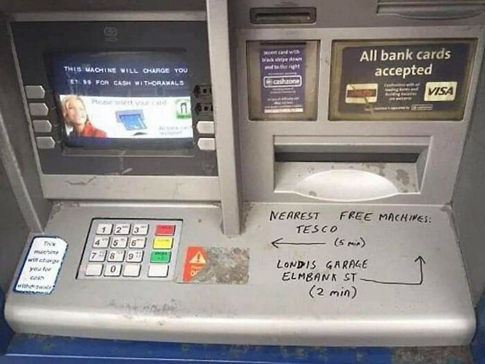 ATM with handwritten vandalism directing users to free nearby cash machines at Tesco and Londis Garage locations