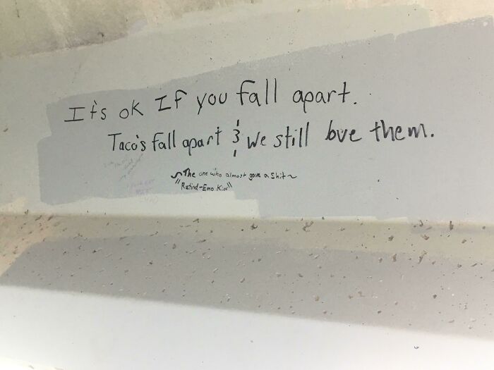 Handwritten vandalism on wall saying it's okay to fall apart, blending humor with relatable public property graffiti.