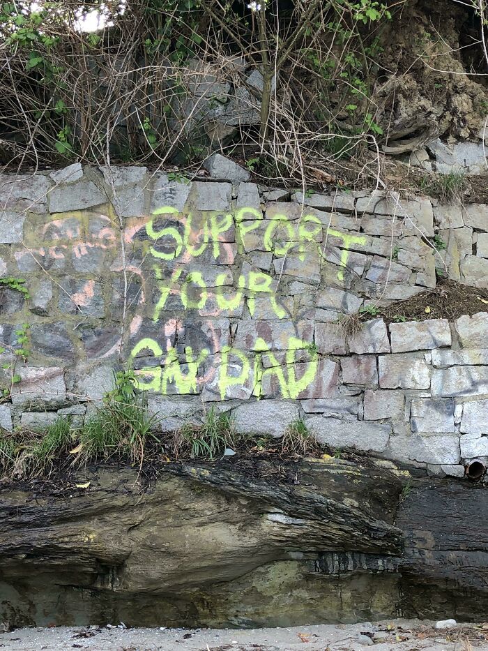 Graffiti on a stone wall reads support your grand, an example of creative vandalized public property art.