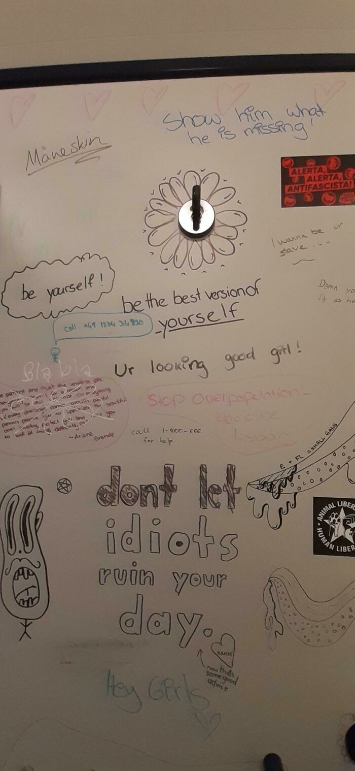 Whiteboard vandalized with positive messages and doodles, showcasing creative public property vandalism and inspiring quotes.