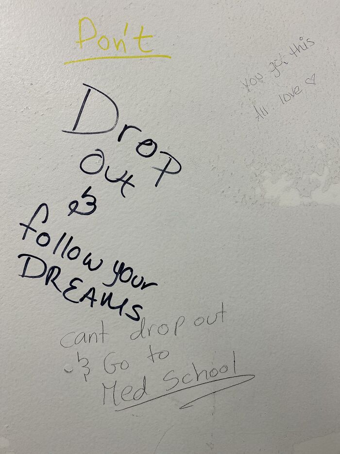 Wall vandalized with encouraging graffiti messages about following dreams and dropping out, showing creative public property vandalism.