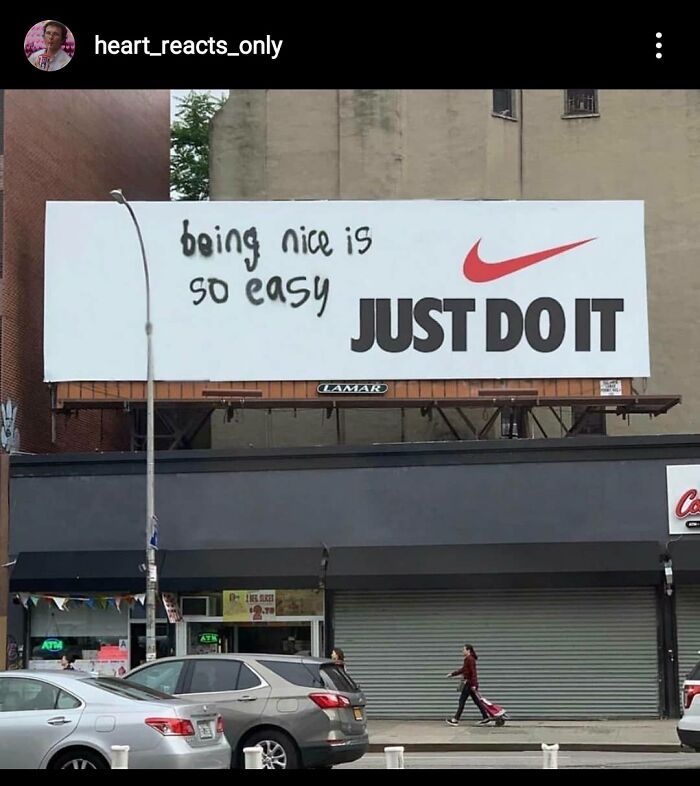 Graffiti alters Nike billboard to say being nice is so easy, showcasing creative vandalized public property on a city street.