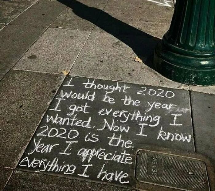 Chalk graffiti on sidewalk reflecting on 2020, a creative example of vandalized public property with a positive message.