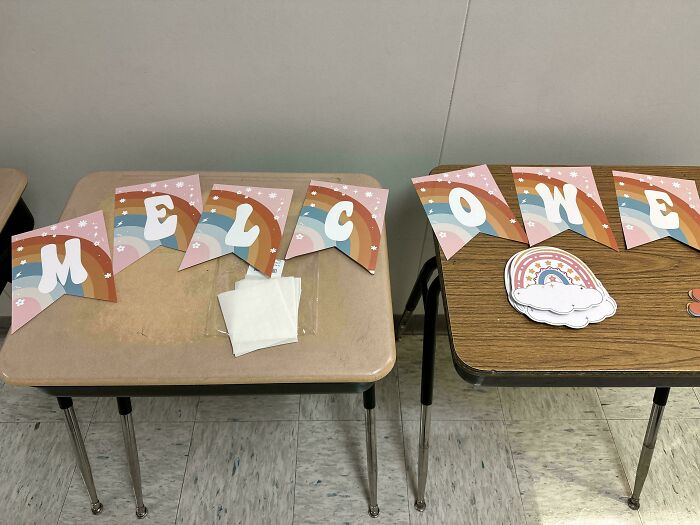 Colorful welcome sign with random notes and messages on two desks, adding a lighthearted touch to the room.