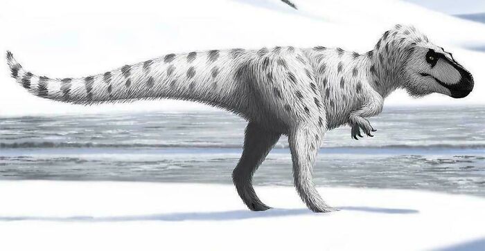 Reconstruction of a prehistoric dinosaur covered in fur, illustrating nature was metal millions of years ago in a snowy landscape.