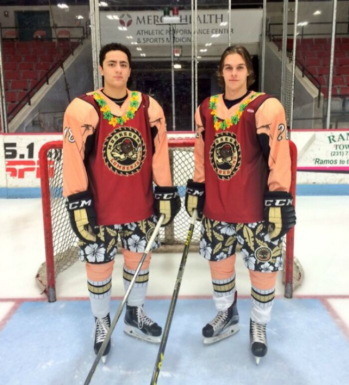 Two hockey players wearing humorous mismatched uniforms with floral shorts on ice rink, showing funny uniform moments.