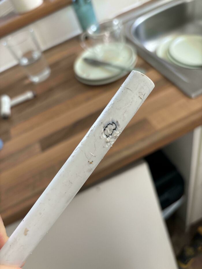 Close-up of damaged white pipe with burn mark in a rental property showing landlords were so horrible renters wanted to run away