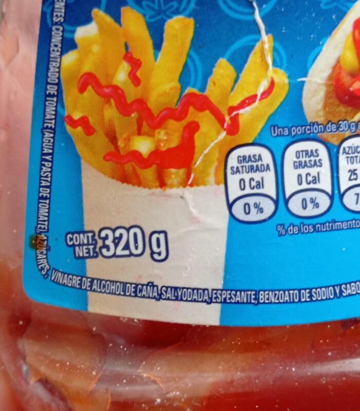 Close-up of ketchup bottle label with a clear Photoshop fail showing fries with oddly placed ketchup squiggles.