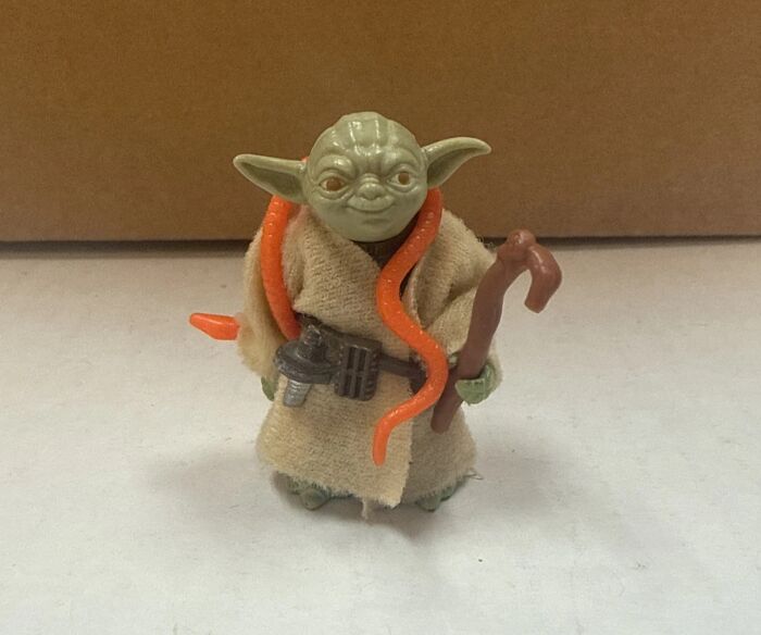 Vintage toys worth fortune rare Yoda action figure with detailed clothing and accessories on display.