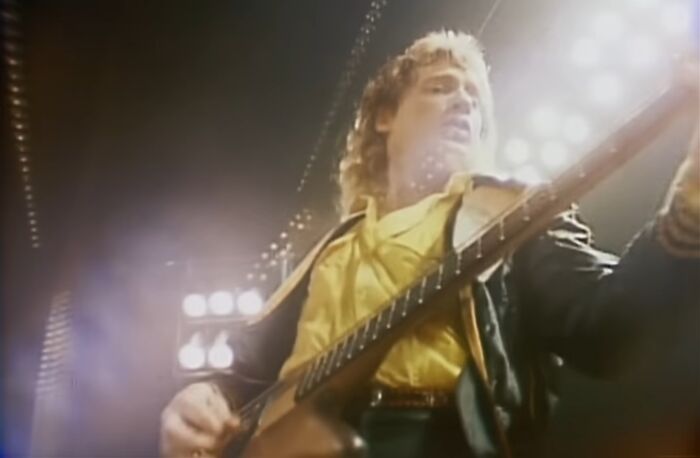 Rock musician playing guitar on stage with bright lights, linked to celebrities who vanished without a trace.