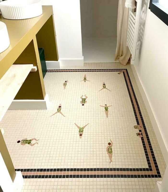 Bathroom floor with clever mosaic tile design of synchronized swimmers, showcasing smart and cool designer creativity.