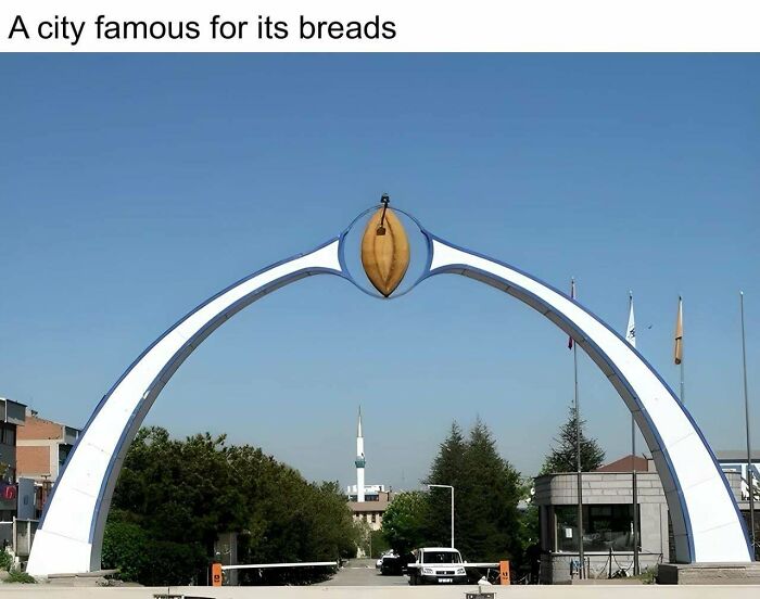 Archway sculpture resembling a bread loaf marking entrance in an urban area illustrating urban hell and societal issues.