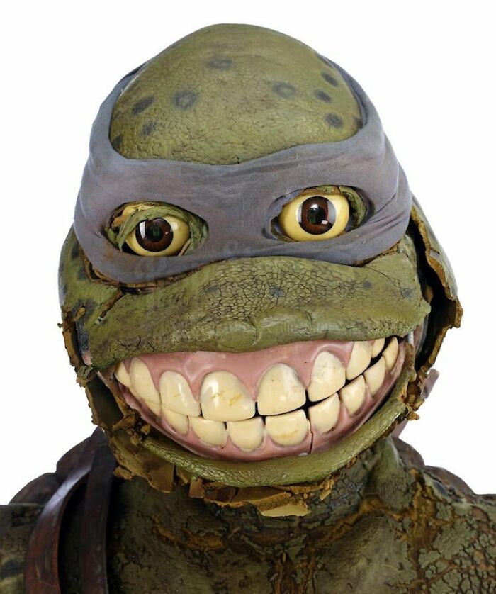 Creepy teenage mutant ninja turtle mask with realistic eyes and large teeth, evoking terrifying photos and stories.