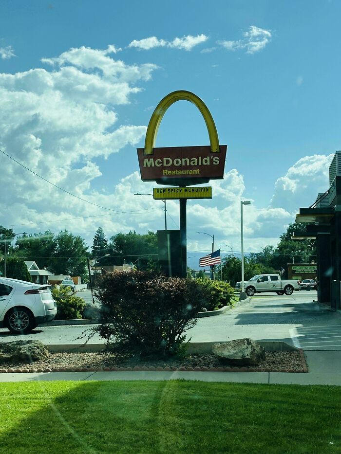 McDonald's sign with the iconic golden arches against a partly cloudy sky, a moderately interesting roadside view.