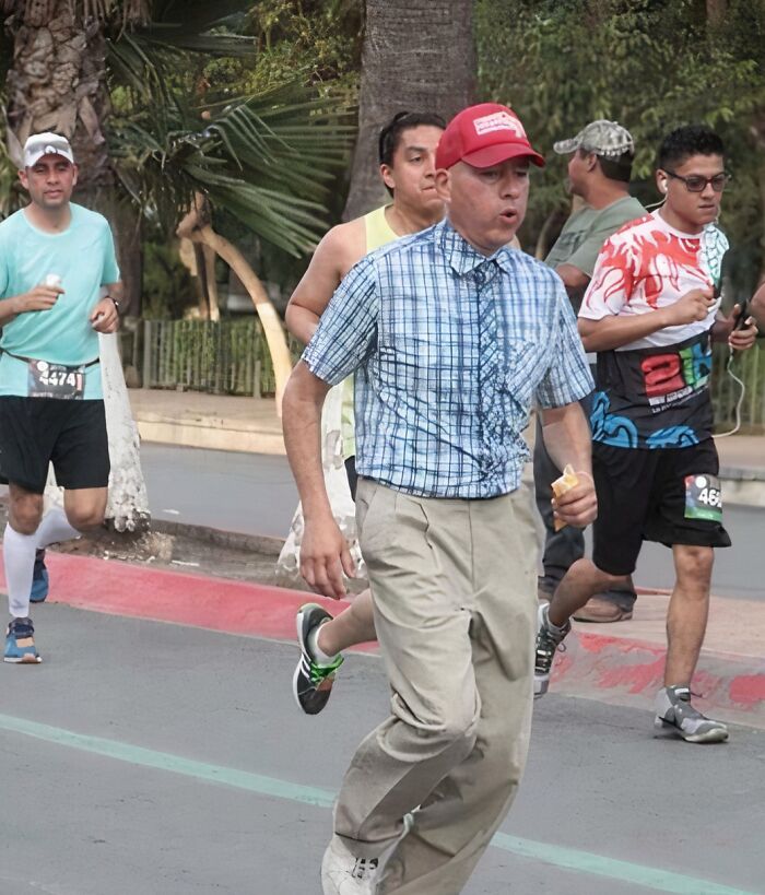 Man in mismatched outfit running a race among casually dressed runners, showcasing a funny uniform moment during an event.