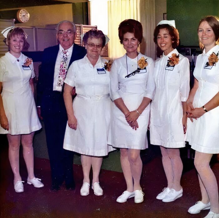 Group of nurses and a man wearing uniforms posing indoors, showcasing moments of wearing a uniform more funny than impressive.