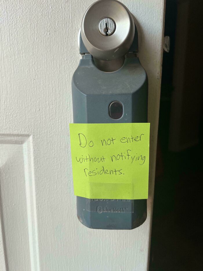 Sticky note on smart lock with handwritten landlord warning not to enter without notifying residents in rental property.