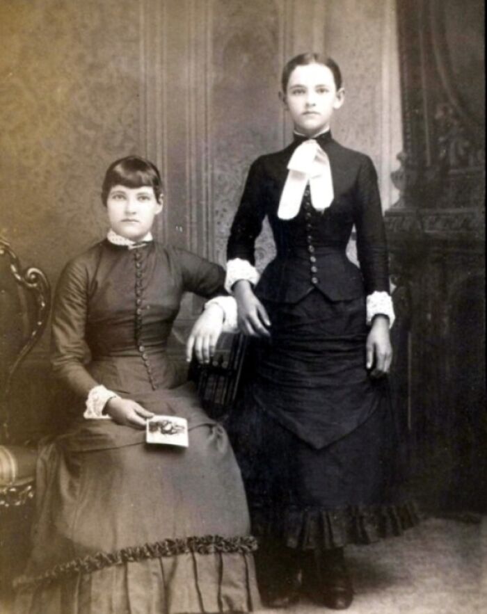 Vintage black and white photo of two women in Victorian dresses, evoking a terrifying and fascinating historical atmosphere.