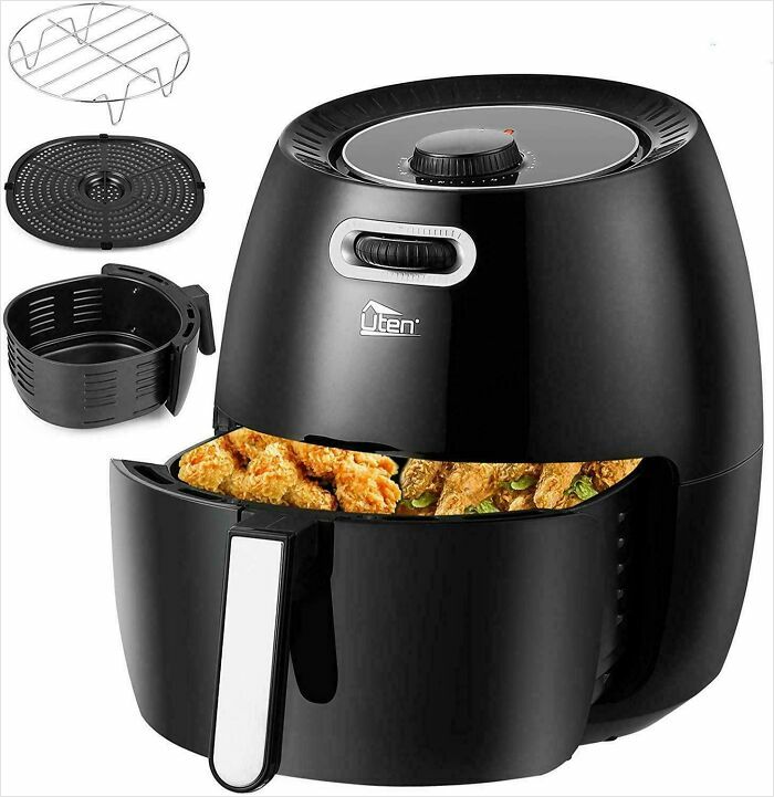 Black air fryer with fried food inside and separate cooking accessories shown, illustrating common Photoshop fails.