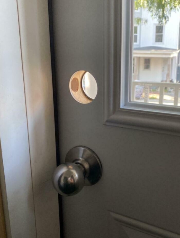 Door with a missing lock, showing a hole above the doorknob, illustrating poor landlord maintenance in rental property.