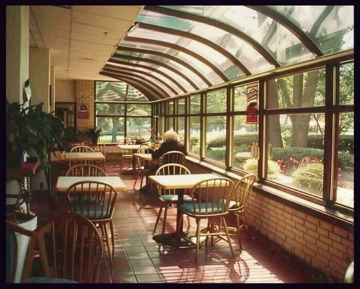 Sunlit retro cafe interior with wooden chairs and tables, evoking ’90s posts nostalgia and unlock memories atmosphere.