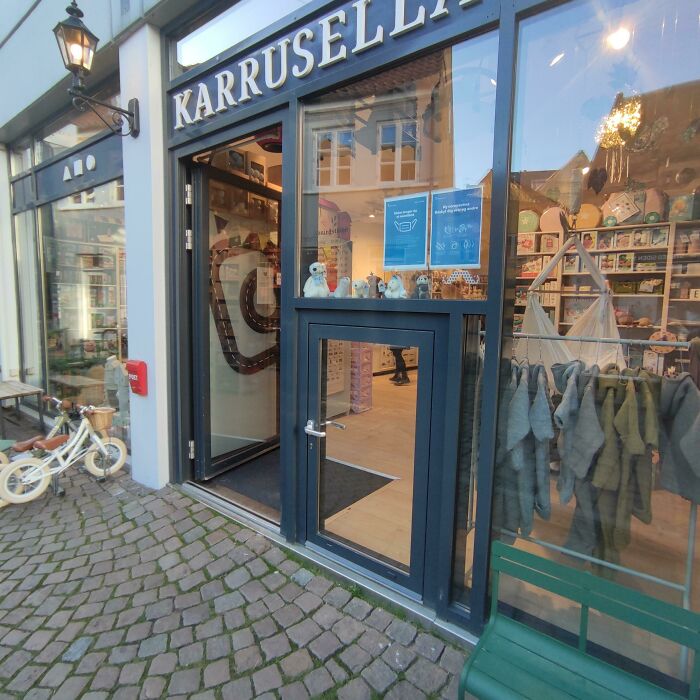 Shopfront of a Danish store on a cobblestone street showcasing local goods, reflecting Danish charm and design.