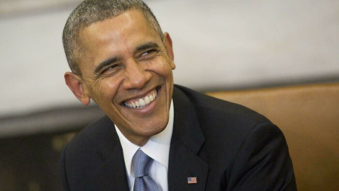 Former president smiling warmly in a formal suit, illustrating perception of time and random comparisons in an online group discussion.