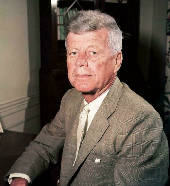 Older man in a plaid suit sitting indoors, representing an online group sharing random comparisons that mess with perception of time.