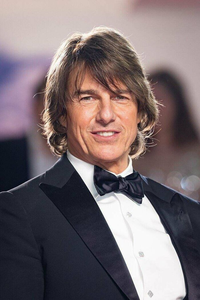 Man in black tuxedo smiling at event, illustrating random comparisons that might mess with perception of time.