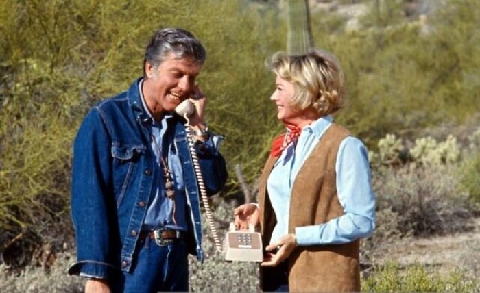 Two people outdoors using a vintage landline phone, illustrating random comparisons that mess with perception of time.