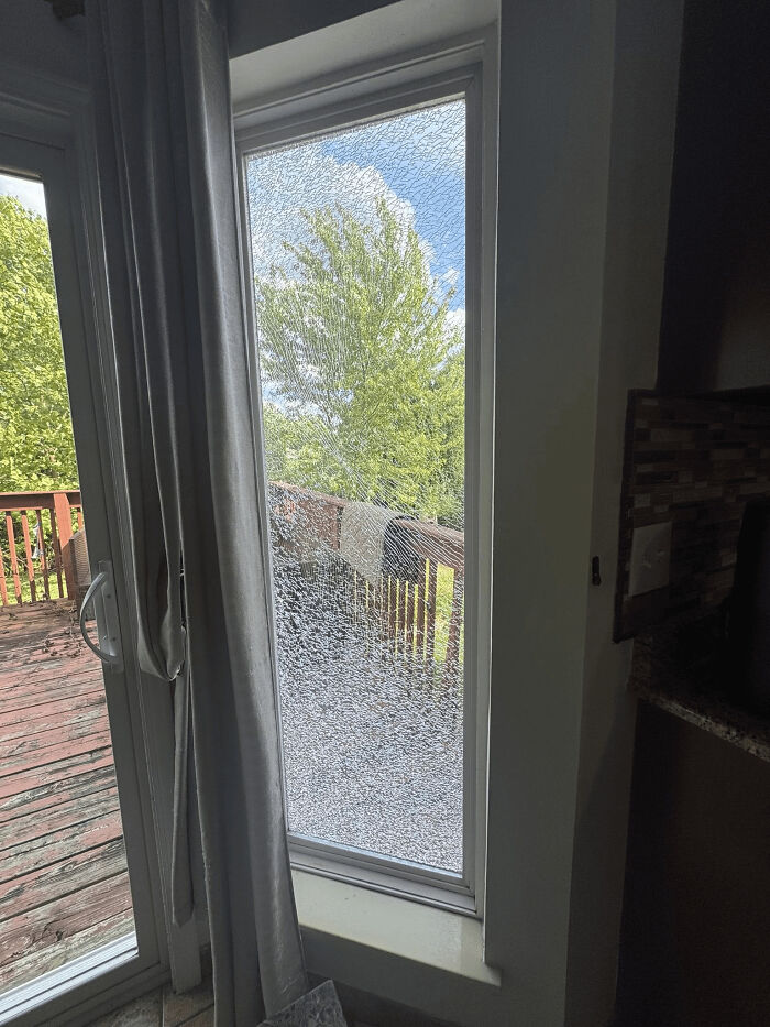 C*****d glass window pane in a home showing an attempt that the universe had different plans outdoors.