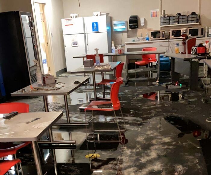 Flooded break room with red chairs and tables, showing poor conditions in one of the worst break rooms ever.