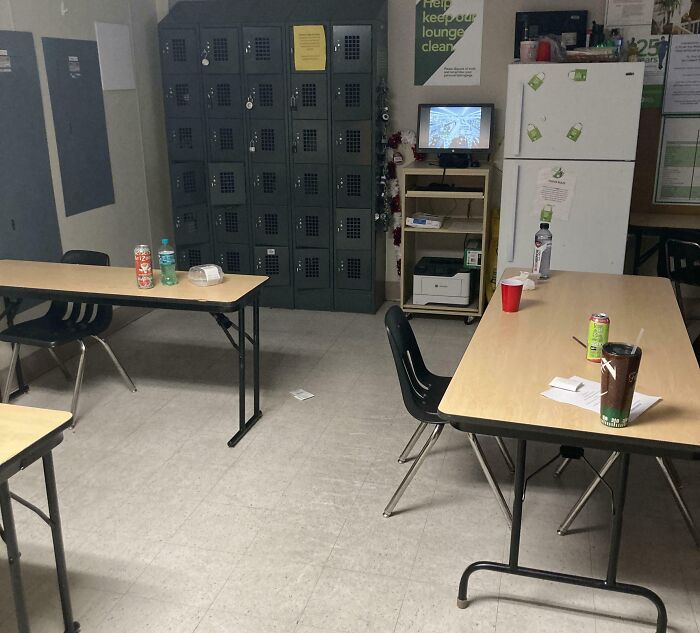 Break room with metal lockers, folding tables, and chairs, resembling a prison environment and feeling cramped.