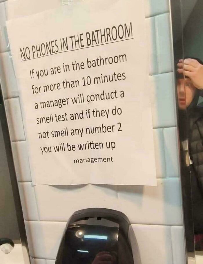 Sign in bathroom stating outrageous job requirements about smell tests if in bathroom over 10 minutes, addressing quick nope out.