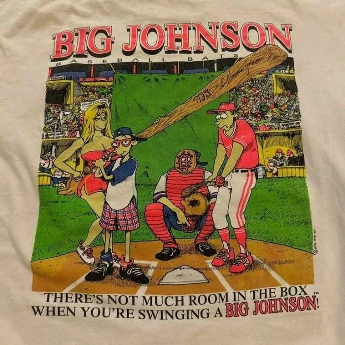 Vintage 90s baseball cartoon on a t-shirt featuring a batter, catcher, umpire, and a woman in the crowd at a stadium.