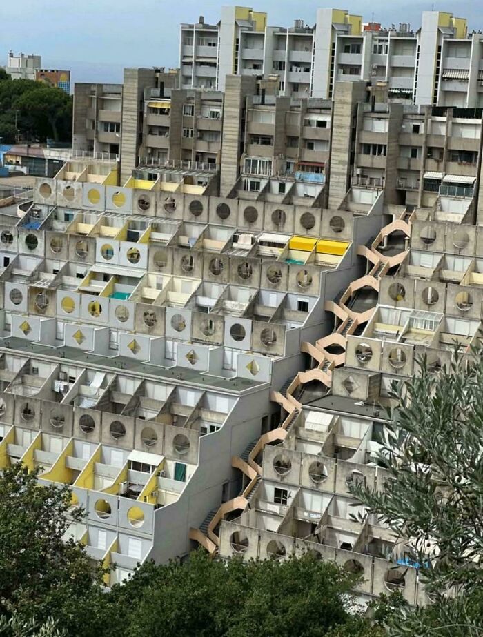 Brutalist urban hell architecture showing a crowded, deteriorating apartment complex highlighting societal issues.