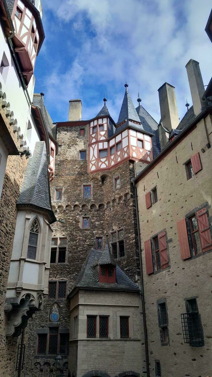 Stone and timber-framed medieval castle architecture under a bright blue sky.
