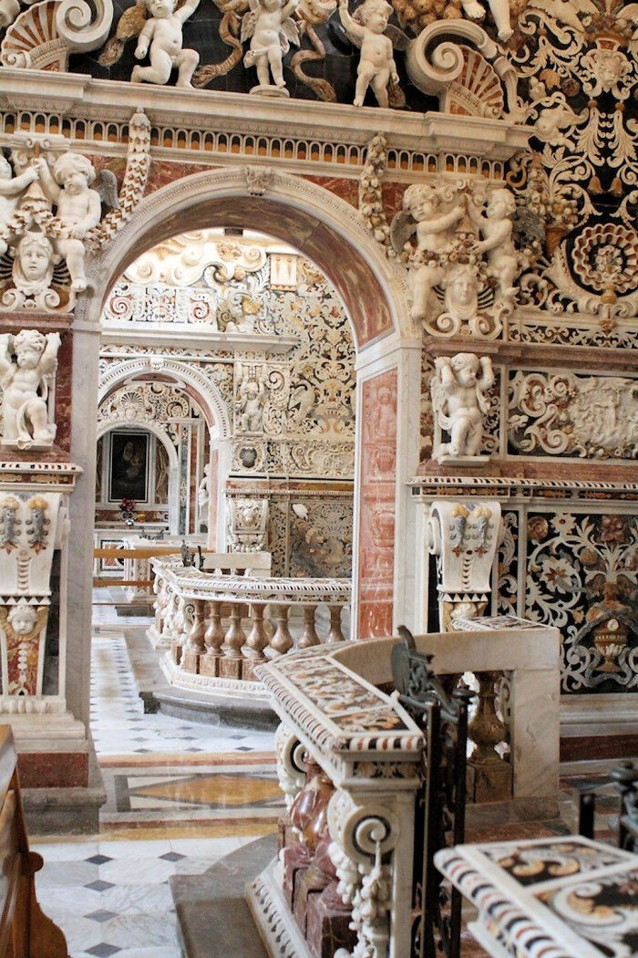 Intricate Baroque interior of a church with detailed carvings and ornate architecture.