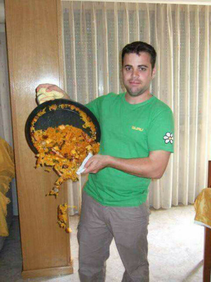 Man in green shirt pouring food from a pan, a perfect timed photo capturing motion better than any Photoshop.